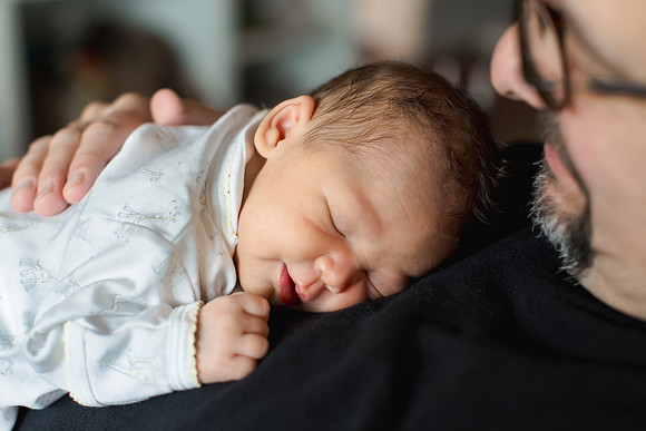 Baby asleep on daddy's chest.