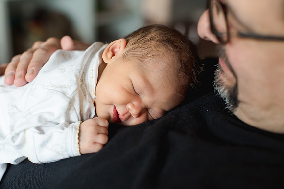 Baby asleep on daddy's chest.